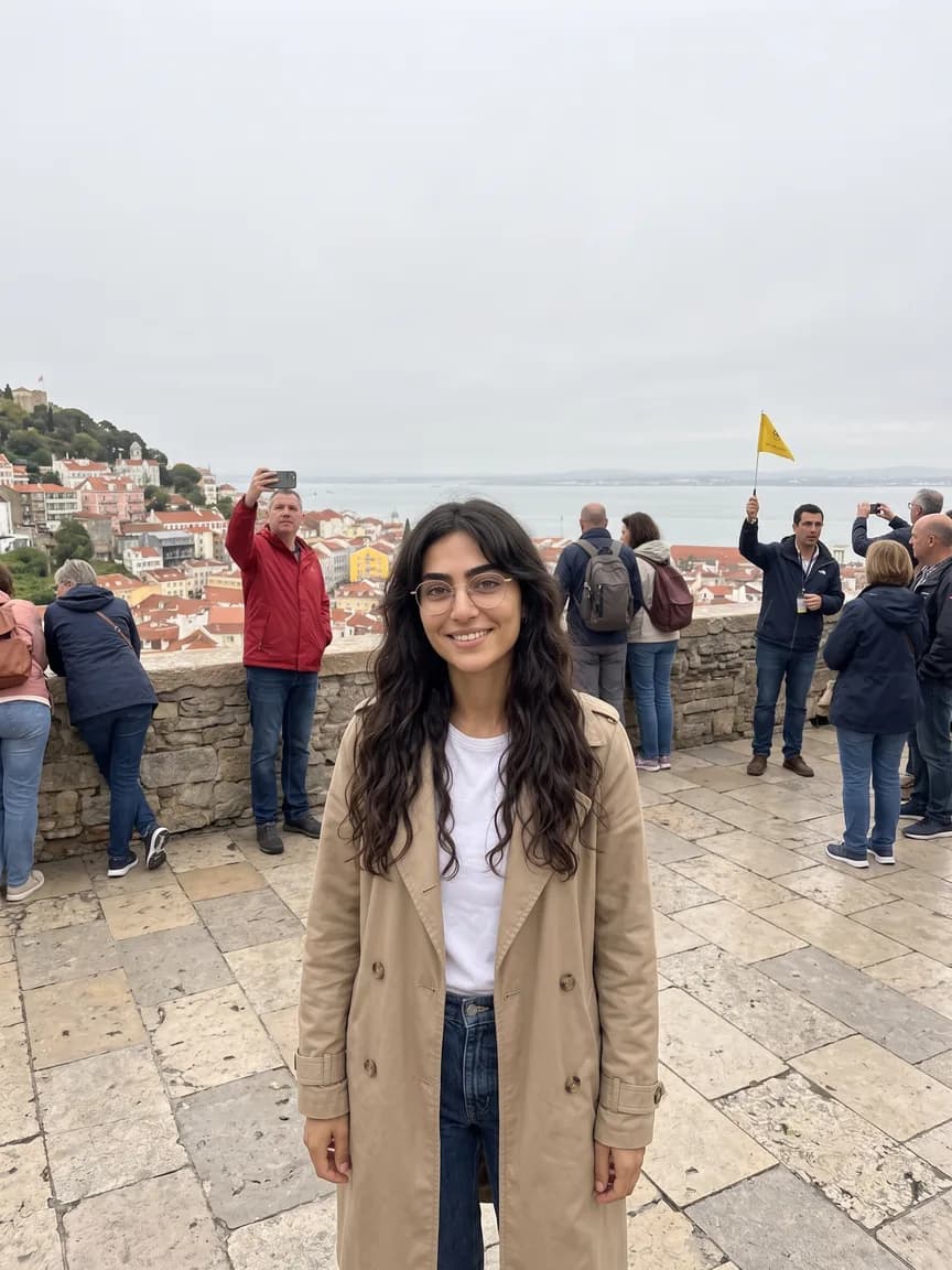 Noor smiling at a crowded Lisbon viewpoint under a grey sky, tourists all around her